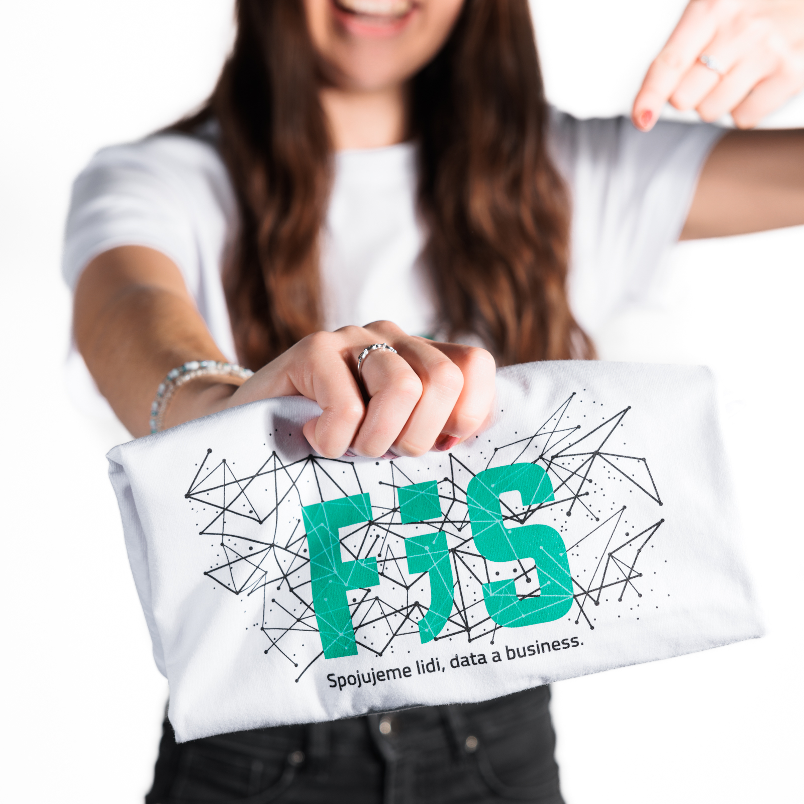 Triko bílé barvy s velkým nápisem F;S přes hrudník, pod nímž se nachází decentní grafika černých čar a teček. Pod grafikou se nachází černý text Spojujeme lidi, data a business.